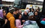 Pessoas fugindo da invasão russa da Ucrânia tentam entrar em um ônibus para a Polônia em um terminal de ônibus de longa distância em Lviv, Ucrânia