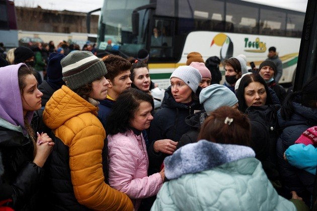 Pessoas fugindo da invasão russa da Ucrânia tentam entrar em um ônibus para a Polônia em um terminal de ônibus de longa distância em Lviv, Ucrânia Pessoas fugindo da invasão russa da Ucrânia tentam entrar em um ônibus para a Polônia em um terminal de ônibus de longa distância em Lviv, Ucrânia