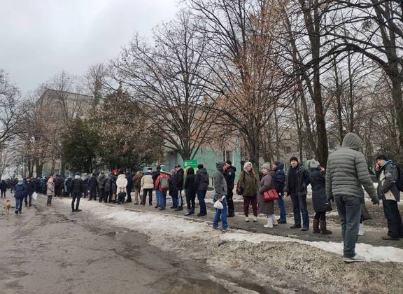 Moradores locais fazem fila para receber comida no território de um hospital, enquanto a invasão russa da Ucrânia continua, em Kharkiv, Ucrânia