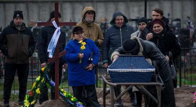 Parentes choram sobre caixão na Ucrânia