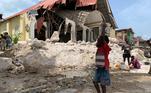 Menino carrega entulho de igreja desmoronada após terremoto em Corail, no Sudoeste do Haiti 