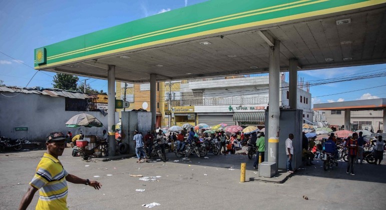 Um homem caminha por um posto de gasolina em Porto Príncipe, em meio a uma escassez de combustível no Haiti
