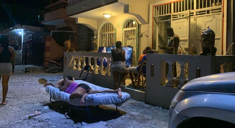 Mulher dorme na rua, à noite, em Les Cayes, cidade atingida por terremoto no Haiti