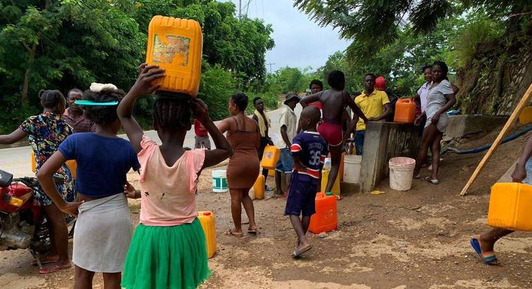 Com risco de contaminação em rios, haitianos precisam de doações de água para tarefas básicas
