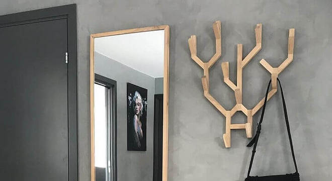 hall moderno decorado com cabideiro de madeira e parede de cimento queimado 