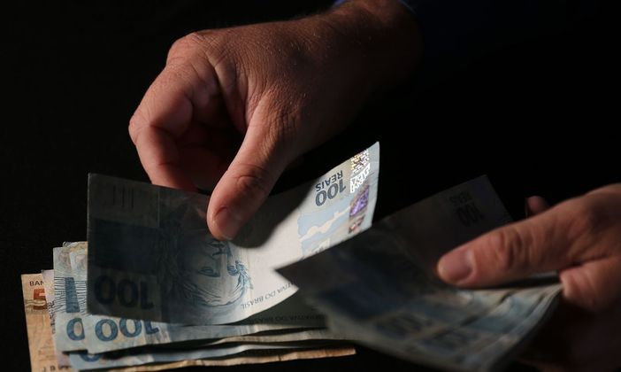 Homem conta notas de R$ 50 e R$ 100. José Cruz / Agência Brasil