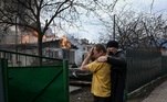 Homem é consolado ao ver sua casa em chamas em Irpin, na Ucrânia