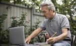 Homem idoso trabalha no computador ao ar livre. Freepik