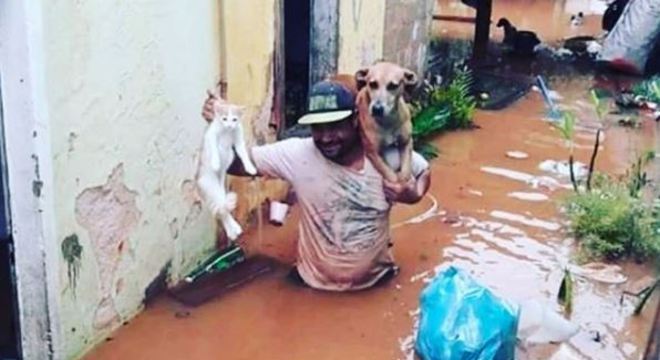 Homem salva gato e cachorro durante enchente em MG