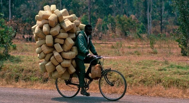 Homem transporta cestas em bicicleta; exercício físico é parte da rotina de muitos ugandenses