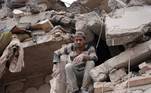 Homem trava em escombros na Síria