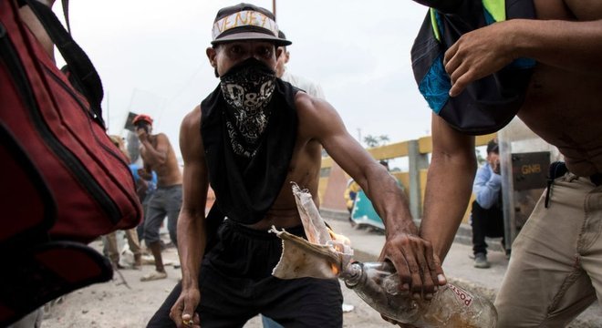 Homens encapuzados protestam durante tentativa de entrada de ajuda humanit&aacute;ria na Venezuela, no fim de semana 