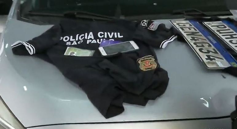 Foram apreendidos o carro, dois uniformes, cartões, celulares, distintivos e placas adulteradas