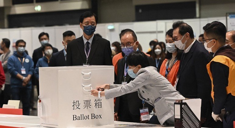 Funcionários eleitorais destravam urna após encerramento das eleições em Hong Kong