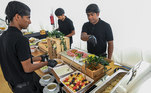 Os funcionários das vilas de fãs preparam as refeições para o público
