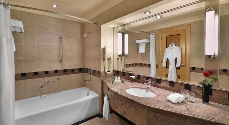 O banheiro da suíte dispõe de banheira, chuveiro, secador e outras facilidades