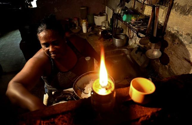 Além de atingir a Flórida, nos Estados Unidos, o furacão Ian também causou muita destruição em Havana, capital de Cuba. Na foto, mulher cozinha em sua casa sem energia elétrica, nesta quinta-feira (29)