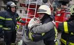 Idosa abraça bombeiro após ser retirada de prédio bombardeado próximo a Kiev, na Ucrânia