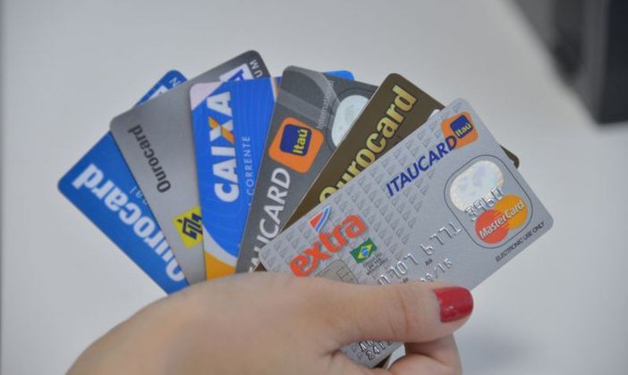 Imagem de mão feminina segurando seis diferentes cartões de crédito. Arquivo / Agência Brasil