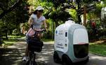 Um ciclista passa enquanto Camello, um robô autônomo de entrega de mantimentos, faz o seu trajeto de delivery, em Cingapura