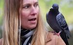 Um pombo pousa-se no ombro de uma mulher no Parque St. James, em Londres (15 de abril). Ela claramente não gostou da atitude desafiadora da aveLEIA MAIS: Porcos e ovelhas são transportados em trem de passageiros na China