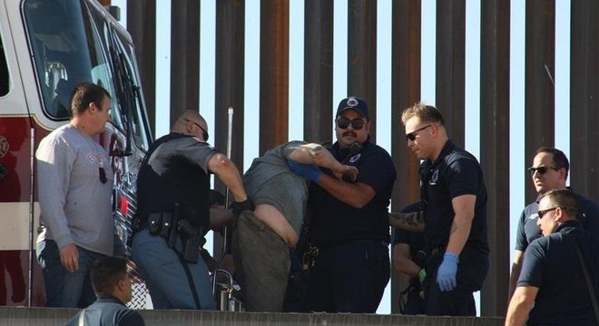 Imigrante é revistado pela polícia na fronteira dos EUA com o México
