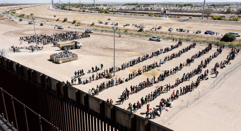 Imigrantes são contidos por agentes da Patrulha de Fronteira após virem de Ciudad Juarez, no México