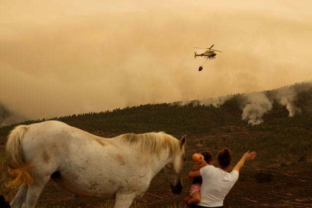 Elianna Diaz, 26 anos, com sua filha Gisella Paz, de 2 anos, e seu cavalo Latina, enquanto incêndios florestais saem de controle em El Rosario, na ilha de Tenerife (Espanha)