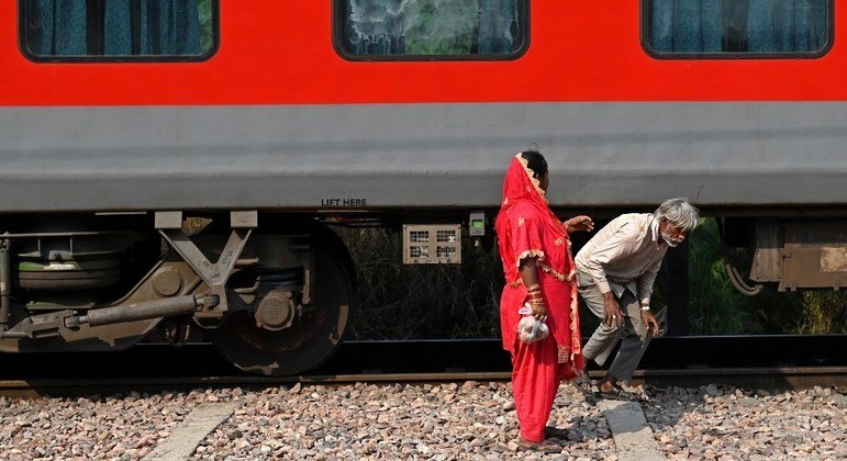 Homem atravessa ferrovia em Nova Déli, na Índia