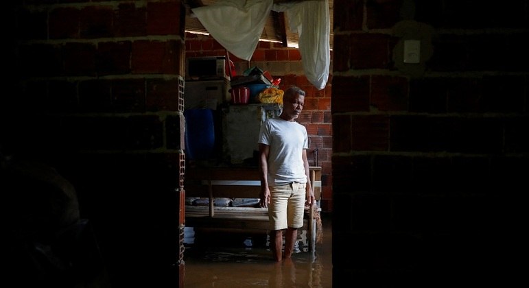 Morador olha desalentado sua casa inundada em Ilhéus, na Bahia
