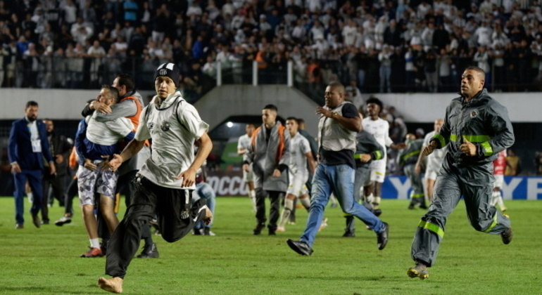 Dezenas de torcedores santistas invadiram o campo após eliminação diante do Corinthians

