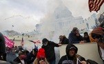 Supporters of U.S. President Donald Trump cover their faces to protect from tear gas during a clash with police officers in front of the U.S. Capitol Building in Washington, U.S., January 6, 2021. REUTERS/Leah Millis TPX IMAGES OF THE DAY