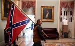 A supporter of President Donald Trump carries a Confederate battle flag on the second floor of the U.S. Capitol near the entrance to the Senate after breaching security defenses, in Washington, U.S., January 6, 2021. REUTERS/Mike Theiler TPX IMAGES OF THE DAY