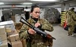 Iryna Sergeyev é a primeira combatente voluntária da Ucrânia a obter um contrato militar completo das Forças de Defesa Territorial da Ucrânia, a reserva militar das Forças Armadas da Ucrânia, segura sua metralhadora Kalashnikov enquanto participa de um treinamento militar em uma garagem subterrânea 