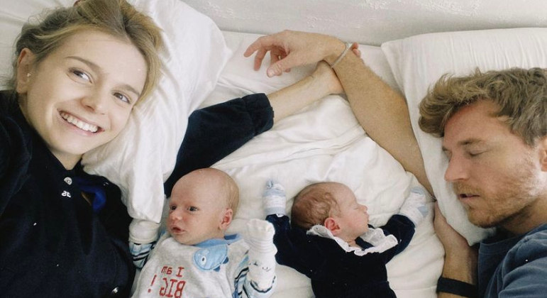Isabella Scherer e o marido, Rodrigo Calazans, deitam com os gêmeos Bento e Mel