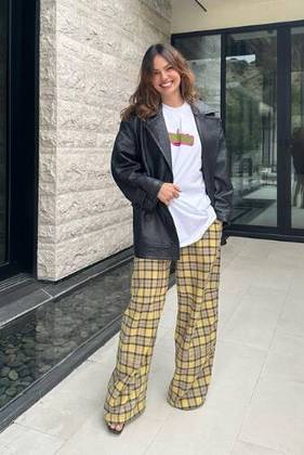 Quer um look confortável e estiloso para ficar em casa? Temos: calça xadrez de modelagem larga, camiseta branca e jaqueta de couro preta. 