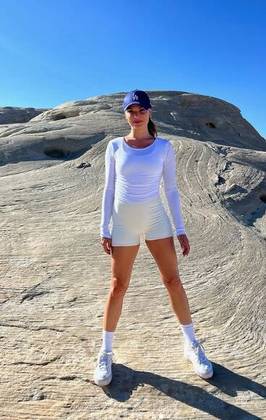 Há uma semana, Isis usou um look esportivo — quase todo branco — para ir ao deserto em Utah. Ela estava de minishort, blusa de manga longa, meias e tênis de salto plataforma. O ponto de cor ficou por conta do boné azul-escuro