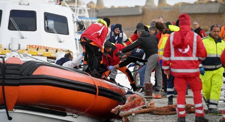Socorristas italianos fazem o resgate do corpo de um migrante