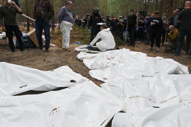 Policiais, militares e desativadores de minas ucranianos estavam ocupados nesta sexta-feira (16) no meio de uma floresta na entrada da cidade de Izium. Após a partida dos russos, uma vala comum de soldados ucranianos e centenas de sepulturas foram encontradas