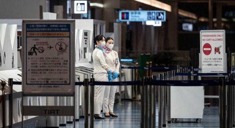 Mulheres trabalham no portão de embarque do aeroporto internacional de Haneda, em Tóquio