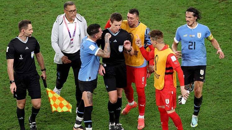 Jogadores do Uruguai rodeiam o árbitro da partida após eliminação na Copa do Mundo