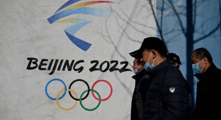 Pessoas passam pelo logotipo dos Jogos Olímpicos de Inverno de Pequim 2022