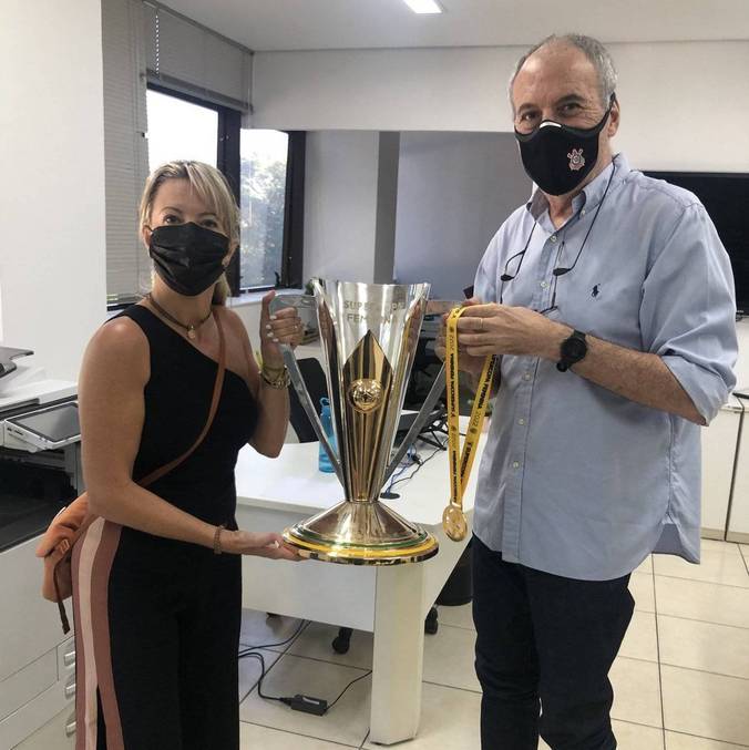 José Colagrossi e a diretora Cris Gambaré posam com a taça da Supercopa