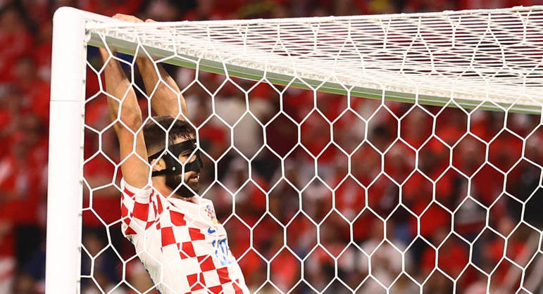 Josko Gvardiol se pendura na trave durante o jogo entre Croácia e Canadá