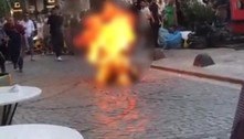 Jovem fantasiado de morte ateia fogo em si mesmo enquanto turistas tiram selfies