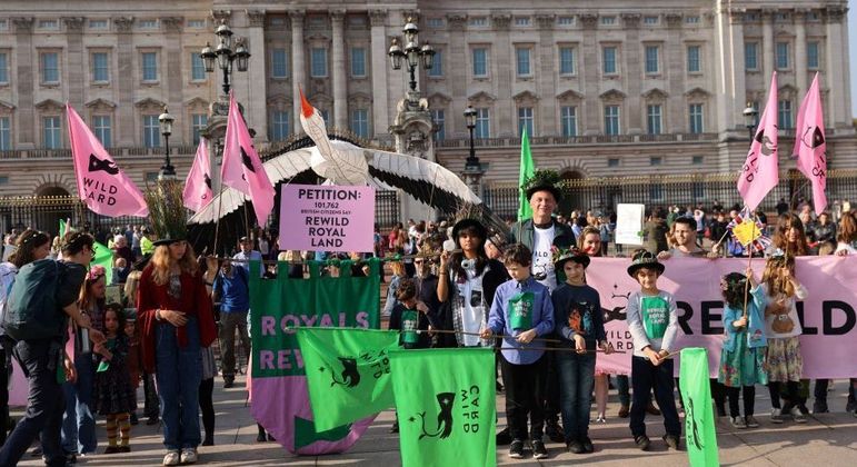 Jovens em frente ao Palácio de Buckingham cobram a família real sobre o meio ambiente 