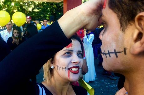 Jovem aplica maquiagem de zumbi em participante
