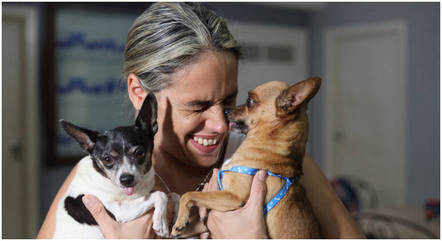 Karolina Vásquez Ramirez brinca com seus cachorros Bingo e Dasha antes de partirem para o aeroporto, em Havana