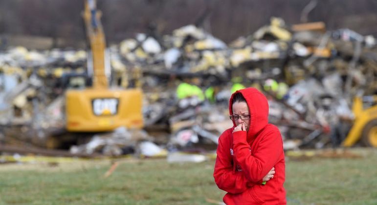Mulher anda no meio dos escombros na cidade de Mayfield (Kentucky)