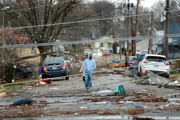 Moradores caminham nas ruas de Bowling Green e observam os estragos causados pela passagem do tornado
